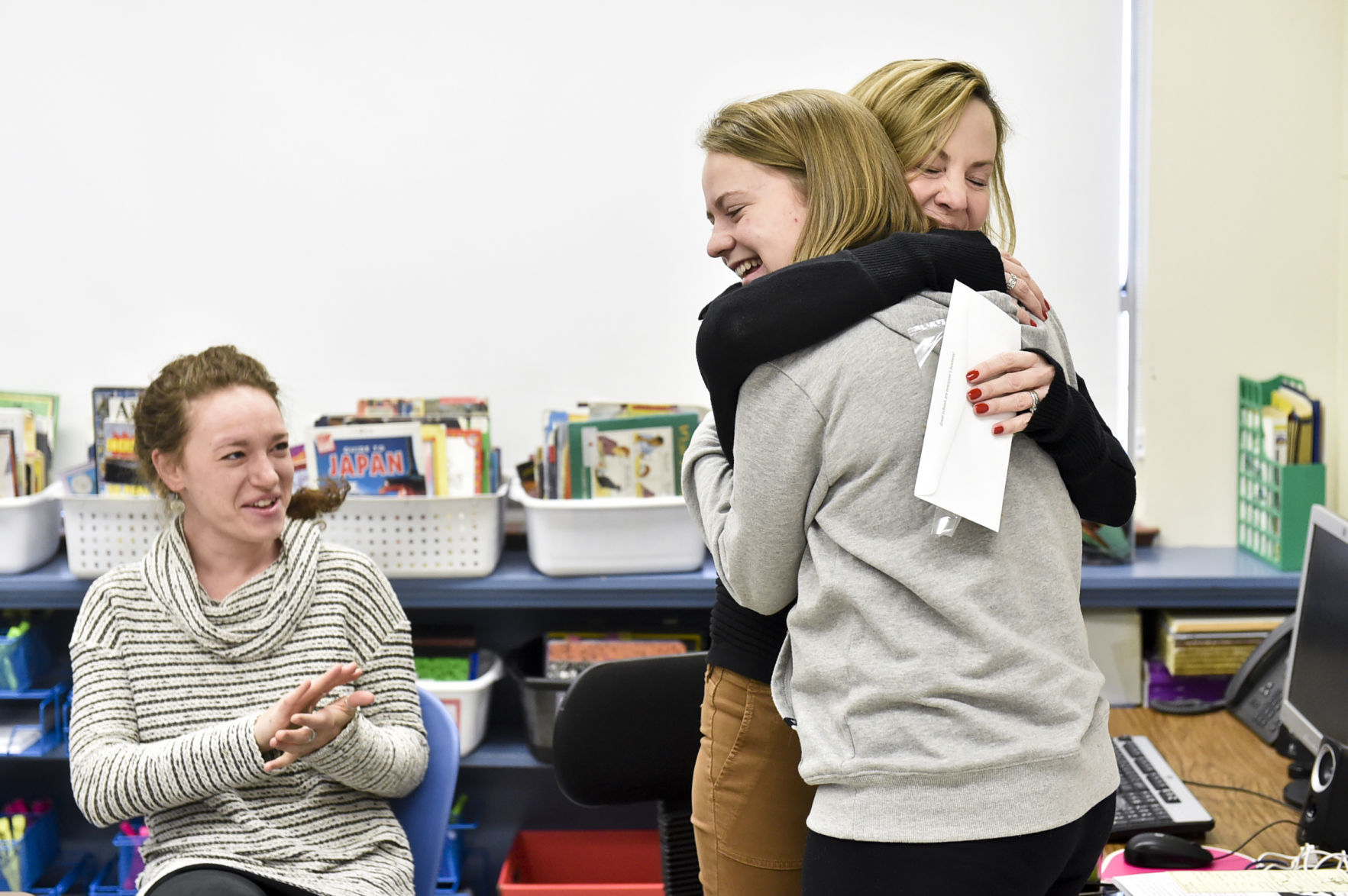 Tasha Peterson, in grey, hugs Smith Elementary School principal, Jill Nyman